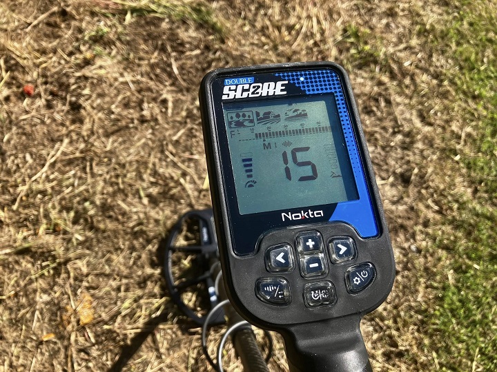 Gros plan sur l'écran LCD du détecteur Nokta Double Score, affichant les indices de conductivité et les modes de recherche.