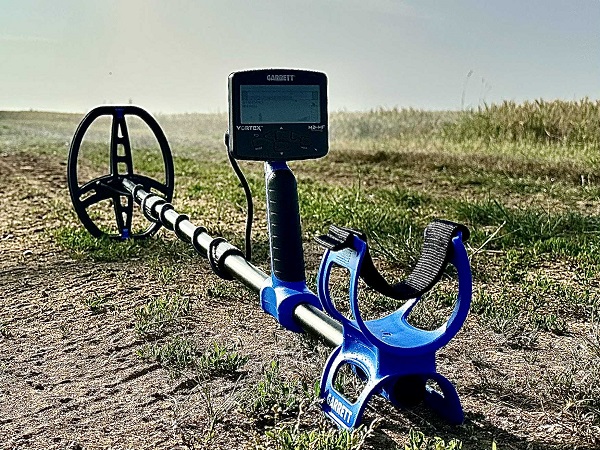 Garrett Vortex VX5 4 Vue détaillée du détecteur de métaux Garrett Vortex VX5 posé sur un chemin de terre avec son écran et son disque de détection.