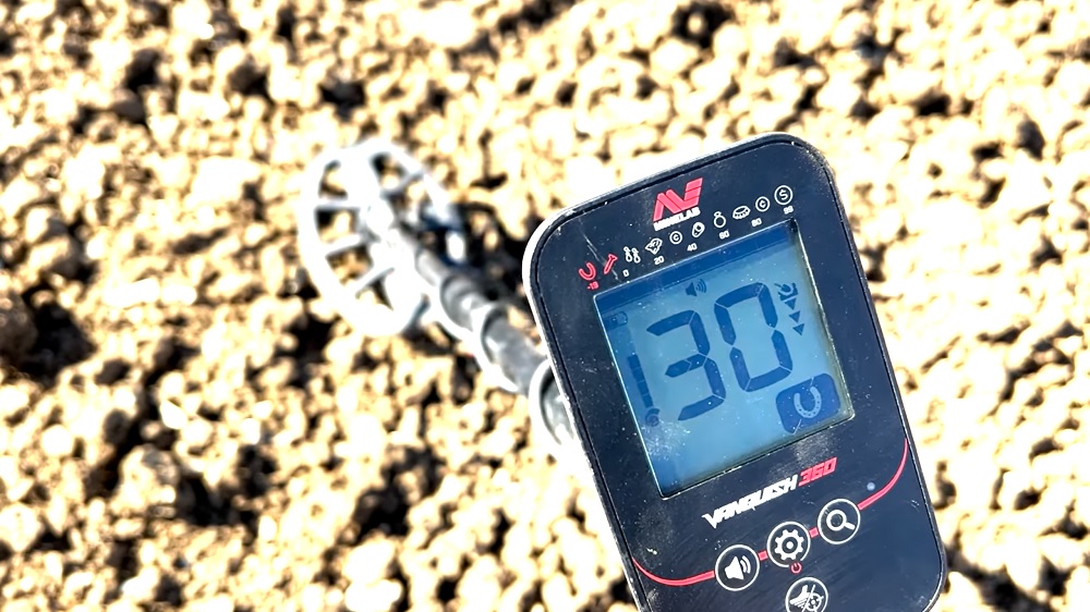 Gros plan sur l'écran LCD du Minelab Vanquish 360 affichant l'indice 30 avec disque Double-D posé dans la terre