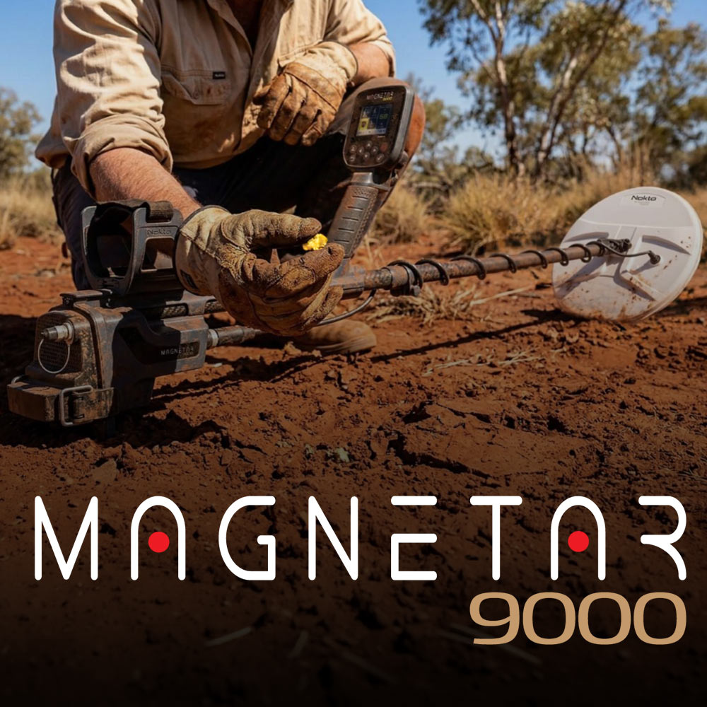 Nokta Magnetar 9000 4 Chercheur d'or tenant une pépite d'or brute sur un sol rouge très minéralisé à côté du détecteur Nokta Magnetar 9000.