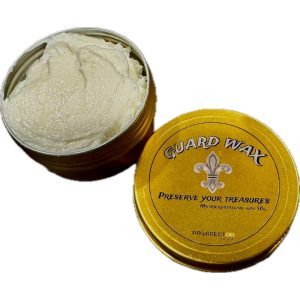 Texture de la creme de protection GUARD WAX dans son pot en metal ouvert a cote de son couvercle.