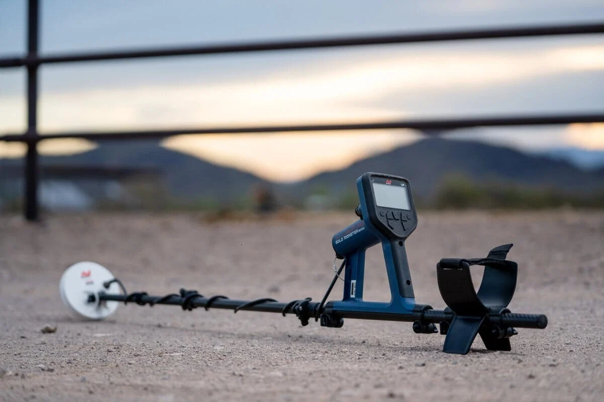 Minelab Gold Monster 2000 : Avis et tests sur le terrain 2 Détecteur de métaux Minelab Gold Monster 2000 et pelle de prospection posés au bord d'une rivière