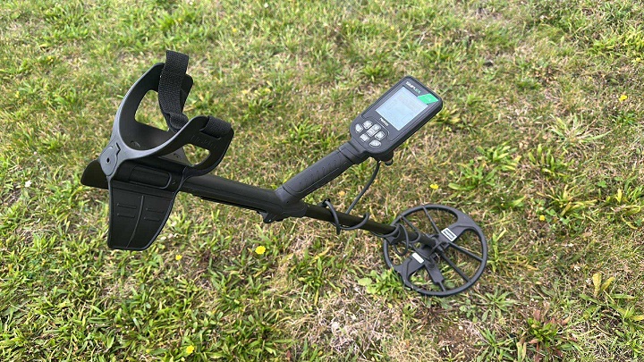 Test du Nokta Simplex Lite sur le terrain : l'avis d'un prospecteur 2 Vue latérale du détecteur de métaux Nokta Simplex Lite assemblé sur herbe verte, montrant le boîtier de commande, le repose-bras et le disque de détection DD de 28 cm.